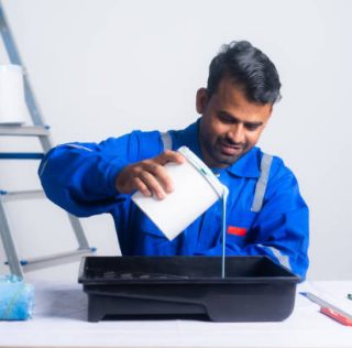 istockphoto-1461053450-612x612 Painter preparing for work by adding paint to box at new home - concept of preparation, blue coller jobs and home improvement or renovation.