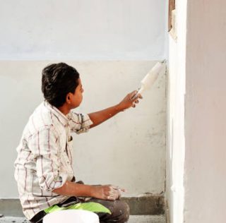 istockphoto-1482449264-612x612 (1) Painter man at work with a paintbrush at home on the wall during Diwali festival.